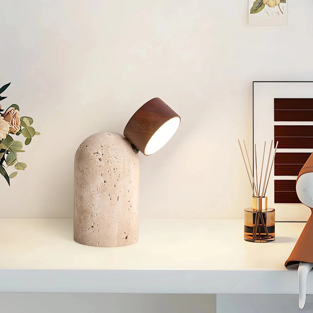 The Sten lamp lit on a white desk beside dried flowers and a reed diffuser