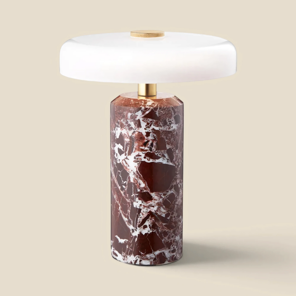 Halo cordless table lamp in burgundy marble with a lit white opal glass shade