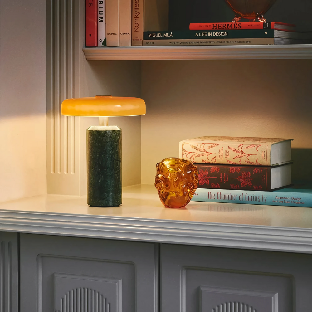 Halo green marble table lamp with amber shade lit on a styled bookshelf, HALO-GREEN-01