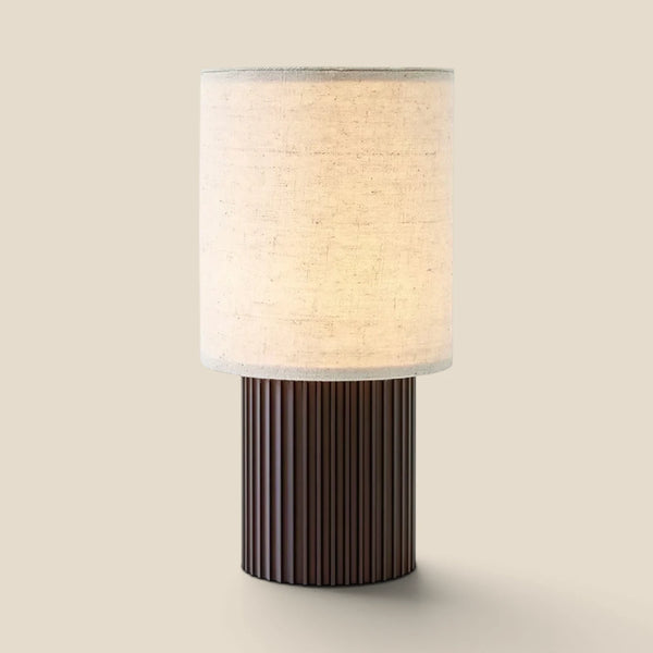 Vensalo Solene rechargeable table lamp, cylindrical canvas shade on a ribbed bronzed brass base, studio view