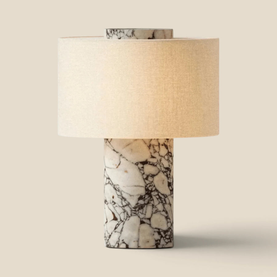 Vensalo Marble Drum table lamp with a natural marble base and warm linen drum shade, lit studio view