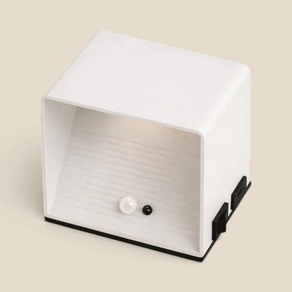 Vensalo Cubo wall light seen from above, white metal body with motion sensor and black magnetic mounting bracket