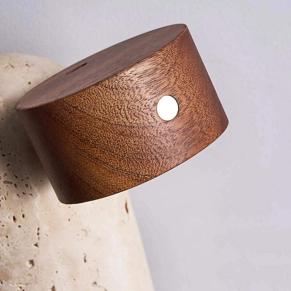 Close-up of the walnut head of the Vensalo Sten lamp, showing the brass button on the side
