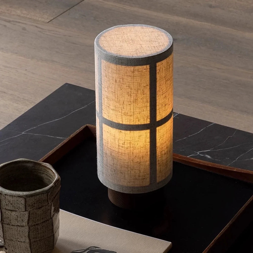 Close view of the lit Washi lamp on a black marble tray, the frame showing softly through the linen shade