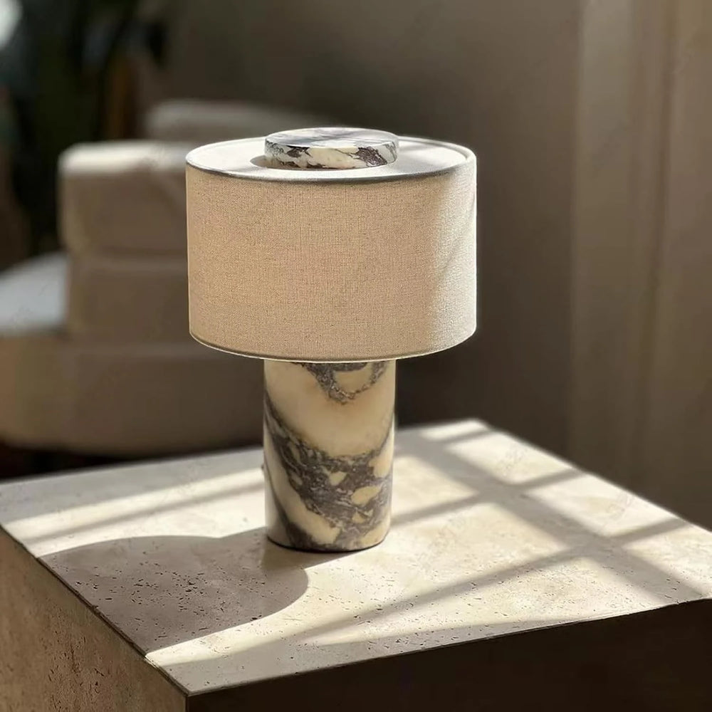 The portable Marble Drum lamp on a travertine block in afternoon window light