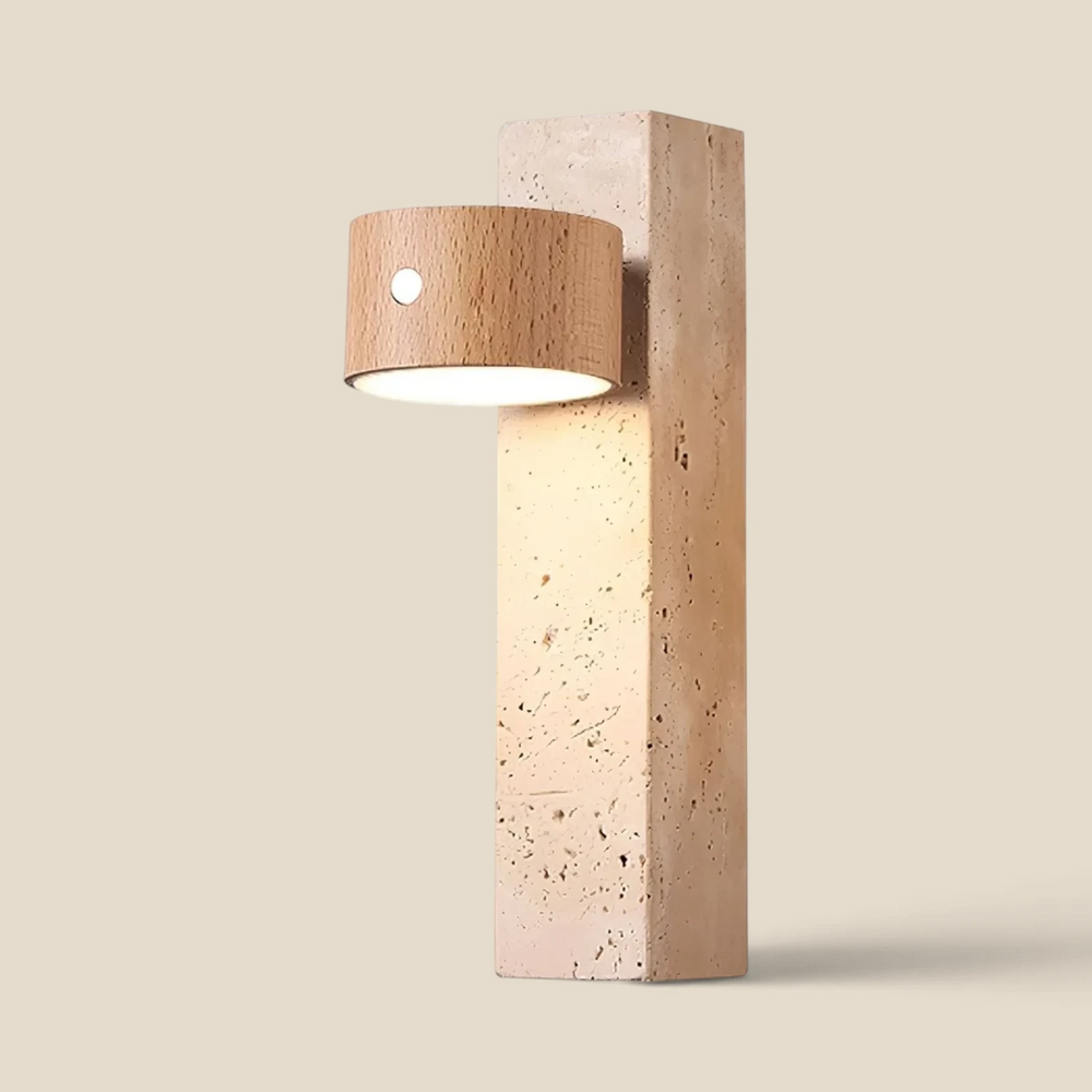 The Vensalo Monolith cordless wall light, a travertine block with an adjustable oak head casting a warm downward glow