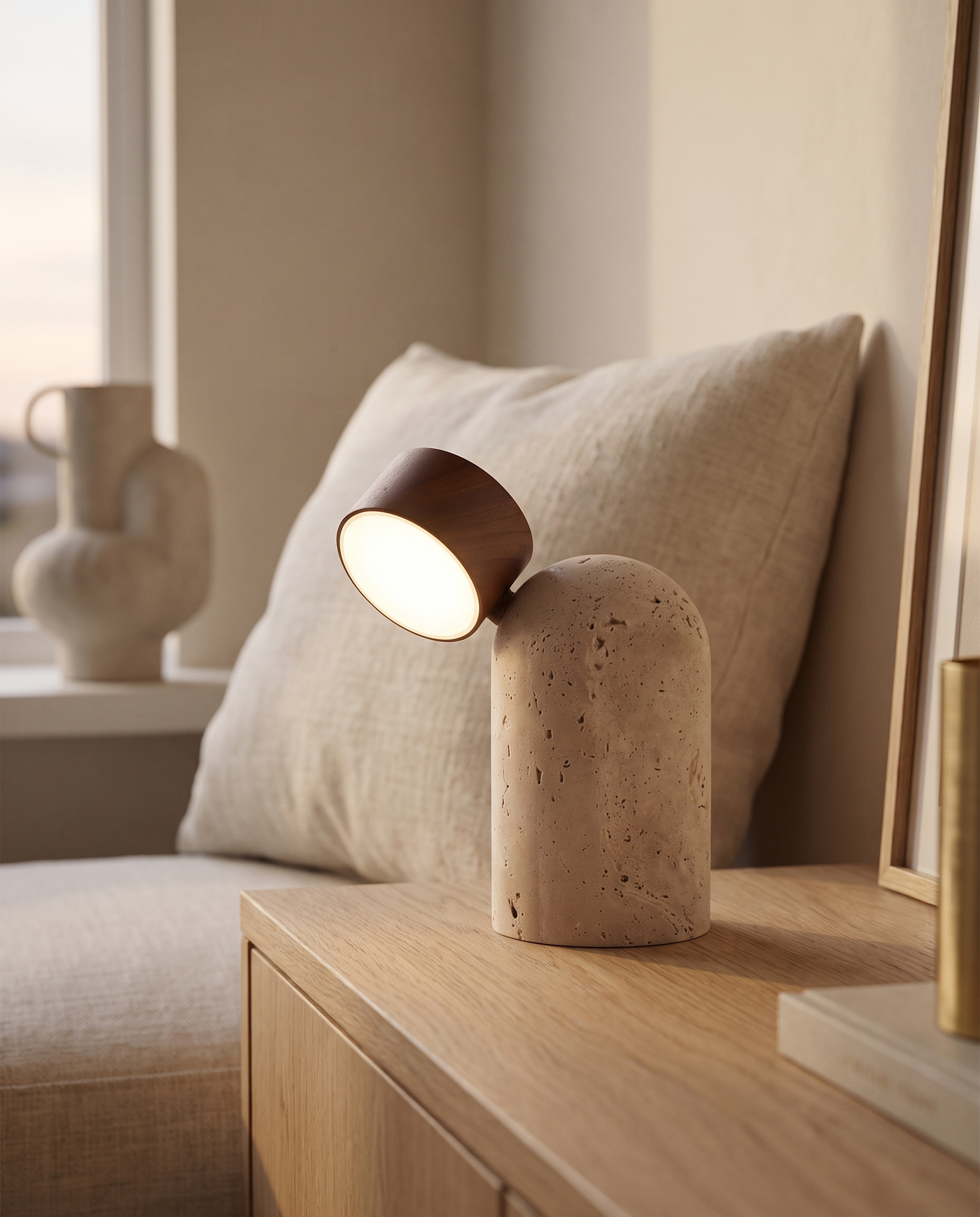 Sten travertine table lamp in Dark Brown, lit on a console table in a warm living room