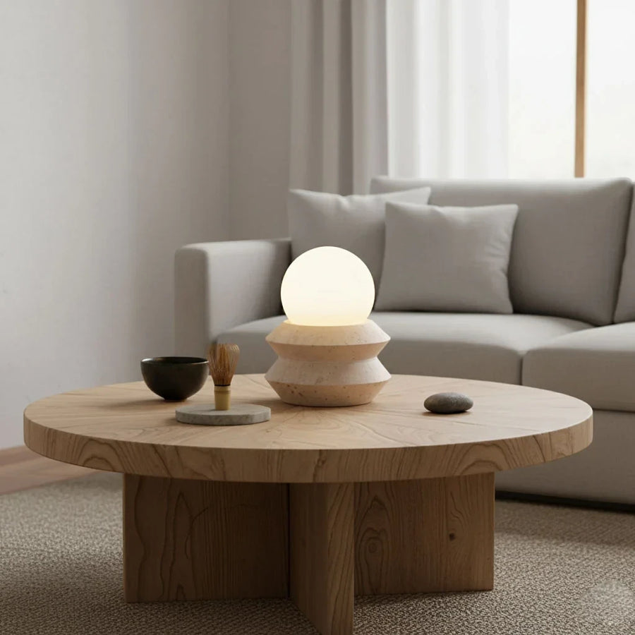 The portable Solace lamp lit on a round oak coffee table beside a matcha bowl and whisk