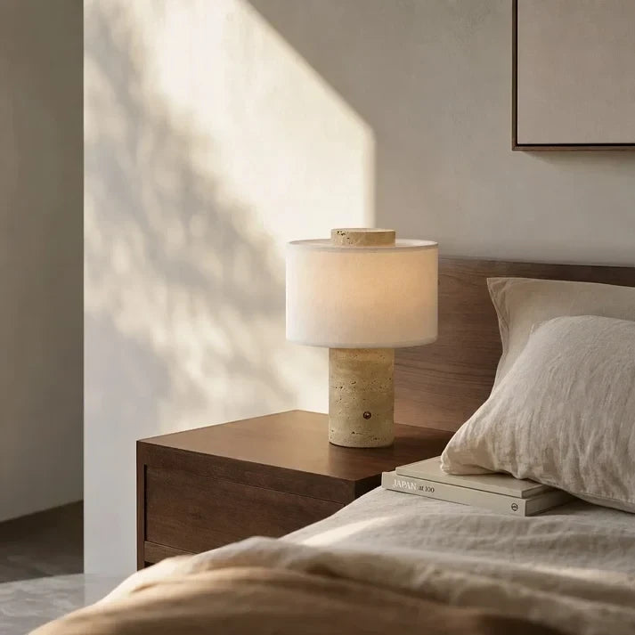 The portable Onyx Cloud lamp on a bedside table in morning light, beside a stack of books