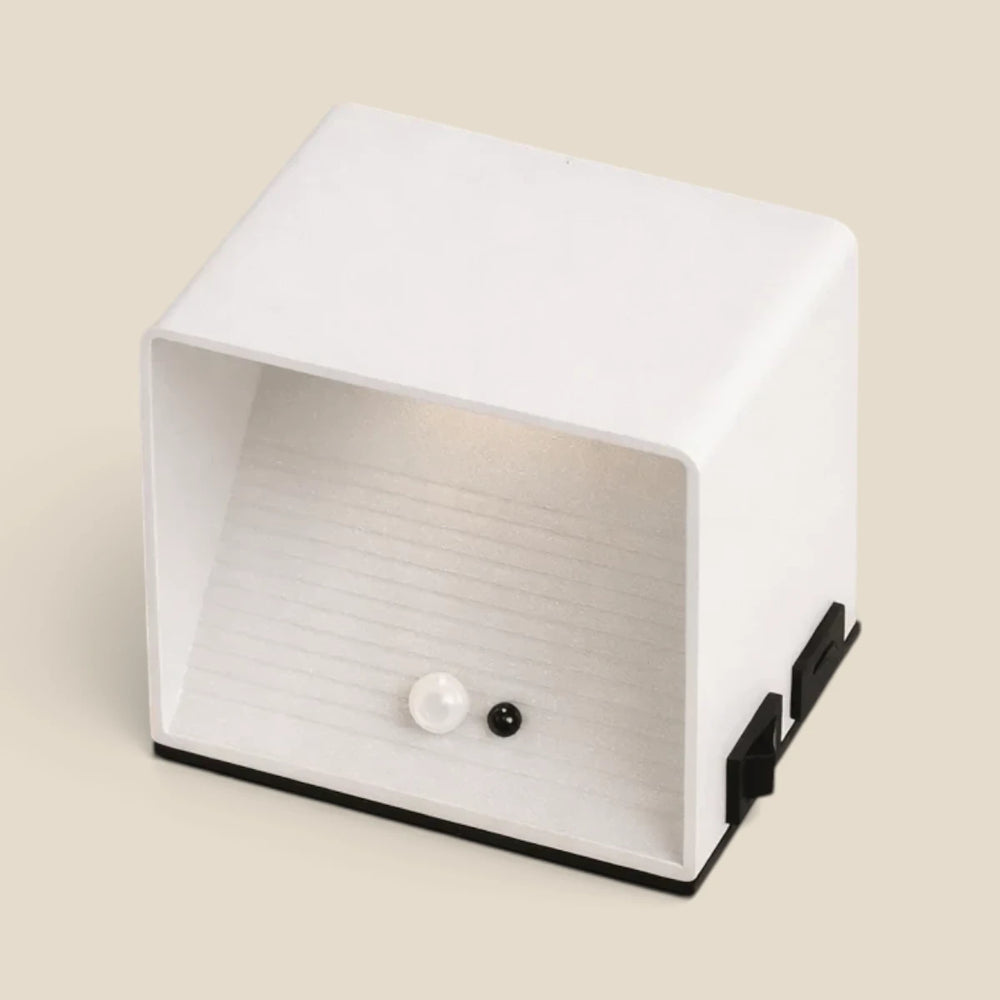 Vensalo Cubo wall light seen from above, white metal body with motion sensor and black magnetic mounting bracket